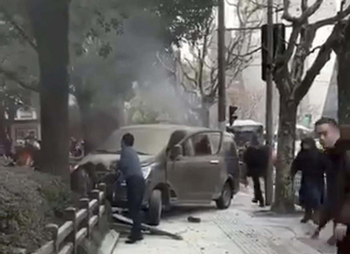 A minivan involved in an accident rests on the sidewalk along a street in Shanghai, Friday. A minivan plowed into pedestrians on a sidewalk in downtown Shanghai on Friday, sending more than a dozen people to hospitals.