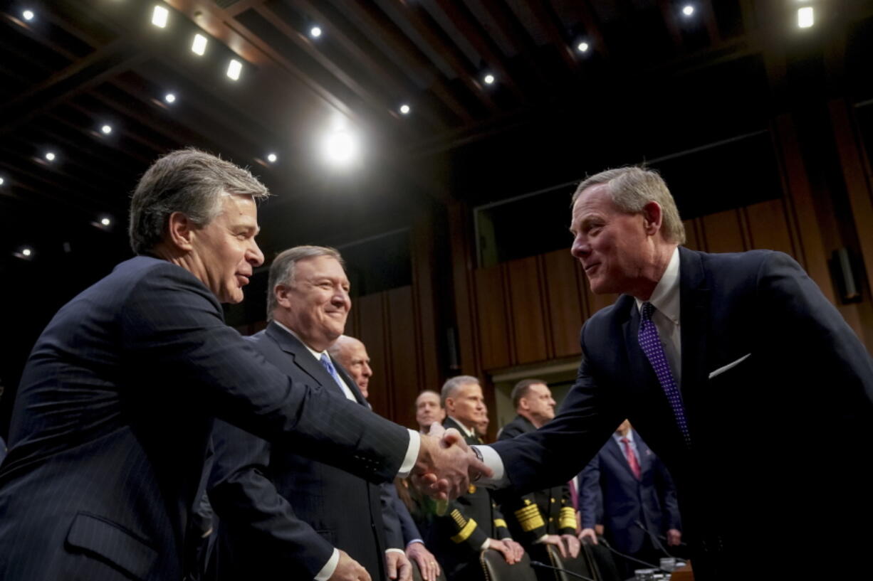 Chairman Richard Burr, R-N.C., right, greets FBI Director Christopher Wray, left, before a Senate Select Committee on Intelligence hearing on worldwide threats, Tuesday in Washington. Also pictured is CIA Director Mike Pompeo, second from left.