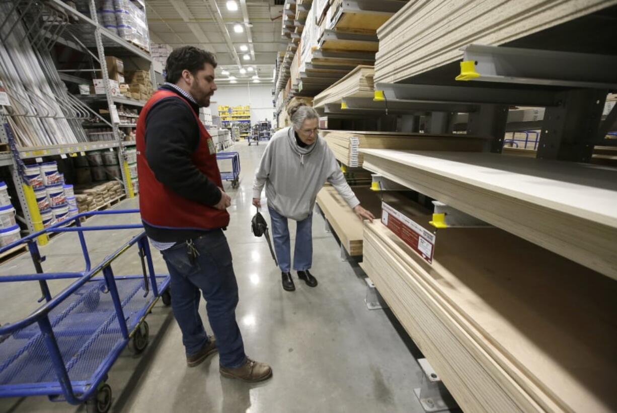 In this Friday, Feb. 23, 2018 photo Lowe’s Assistant Store Manager Patrick Mulloney, of Marlborough, Mass., left, assists customer Karen Frank, of Framingham, Mass., right, at a Lowe’s retail home improvement and appliance store, in Framingham. On Tuesday, Feb. 27, the Conference Board releases its February index on U.S. consumer confidence.