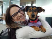 In this undated photo provided by Free Korean Dogs, Canadian figure skater Meagan Duhamel poses with her dog Moo-tae, right, in South Korea. Duhamel already has one life-changing souvenir from South Korea, and it’s not a medal. The Olympic pairs skater rescued a puppy from the Korean dog meat trade while competing in Pyeongchang last year, and she’s helping organize more adoptions while skating there at this year’s games.