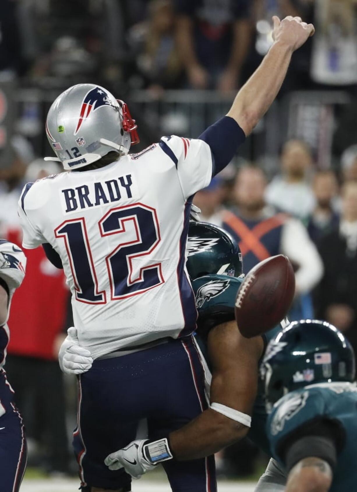 Philadelphia Eagles’ Brandon Graham, center, strips the ball from New England Patriots quarterback Tom Brady during the second half of the NFL Super Bowl 52 football game Sunday, Feb. 4, 2018, in Minneapolis. The Eagles recovered the fumble.