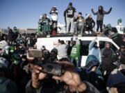 Philadelphia Eagles stand atop a news van while waiting for the team to deplane Monday at Philadelphia International Airport a day after defeating the New England Patriots in Super Bowl 52.