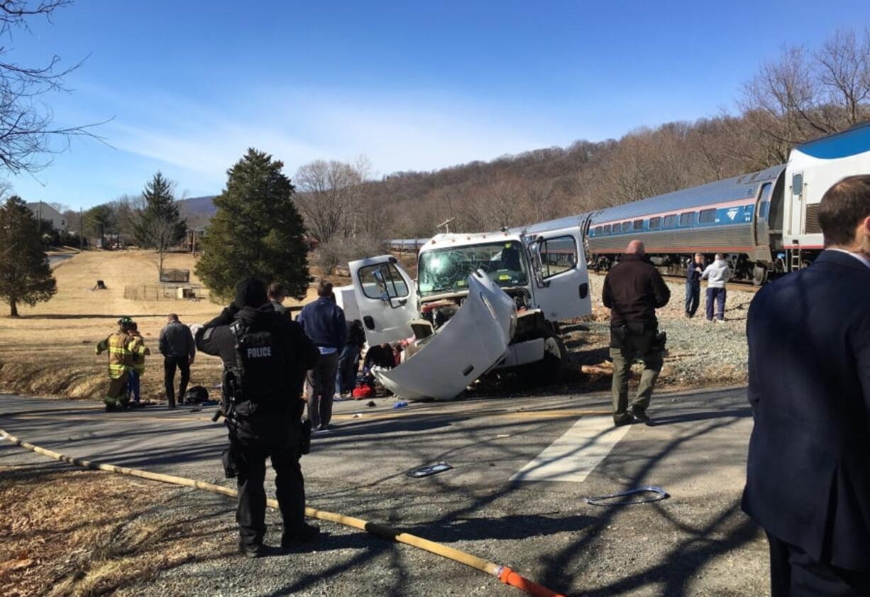 This photo provided by Rep. Bruce Poliquin, R-Maine shows emergency personnel standing near a chartered train carrying members of Congress after it hit a garbage truck in Crozet, Va., Wednesday, Jan. 31, 2018. No lawmakers were believed injured.