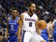 Gonzaga guard Silas Melson (0) reacts after dunking the ball while BYU guard Jahshire Hardnett (0) looks on in the first half of an NCAA college basketball game Saturday, Feb. 24, 2018, in Provo, Utah.