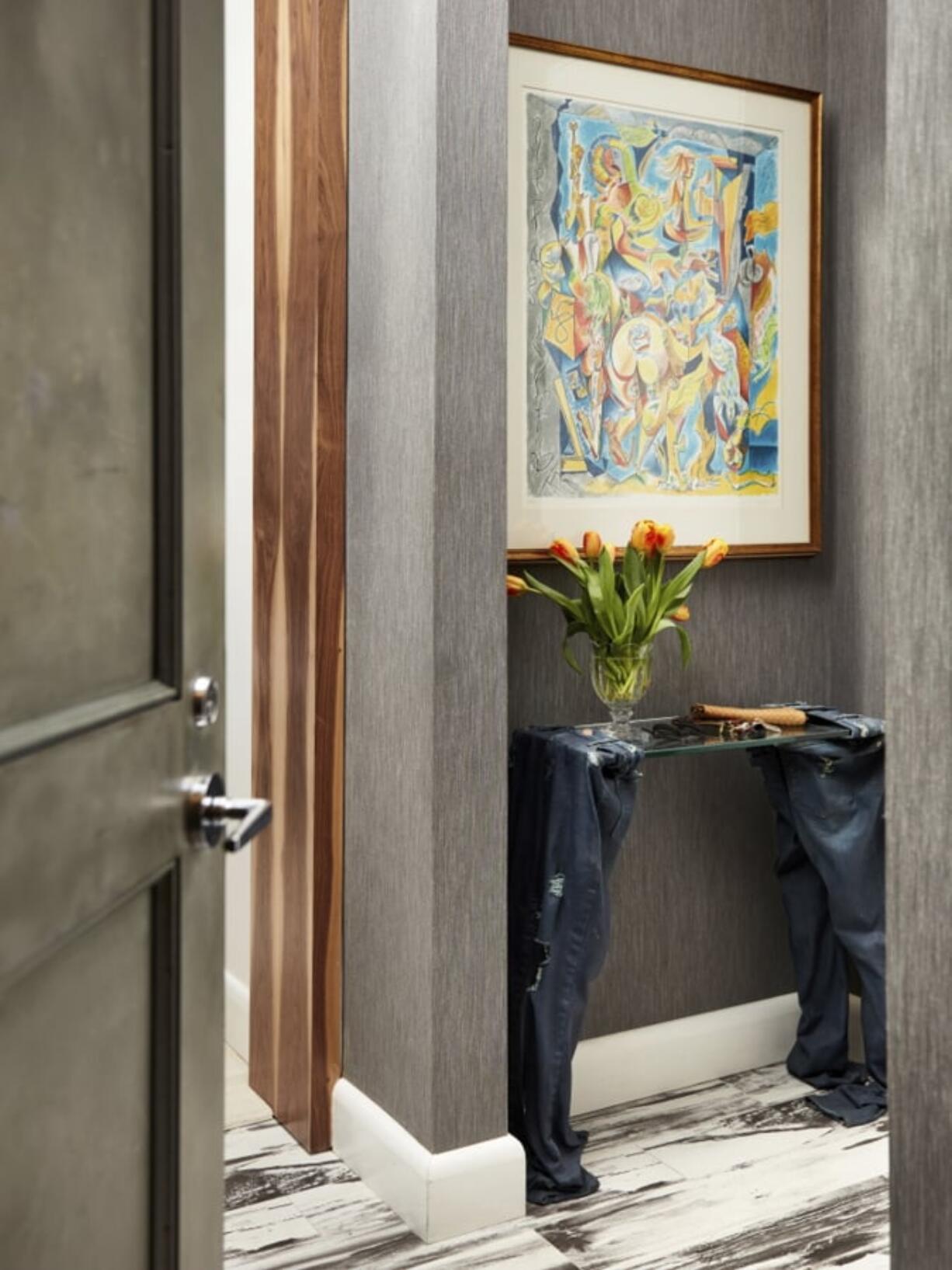 Fresh flowers in the entrance of a home, as seen here on a distinctive console table in this entryway designed by New York-based interior designer Jenny Kirschner. The flowers are a quick and easy pick-me-up for late winter days.