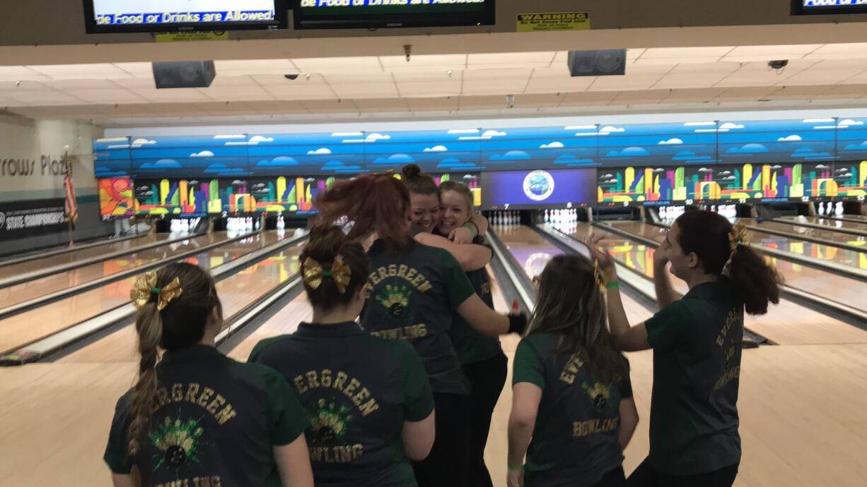 Kerissa Andersen (left facing) is flocked by her teammates after a final-frame strike Saturday to help the Evergreen Plainsmen capture the 3A state bowling title. It's the second consecutive state title for Evergreen.