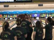 Kerissa Andersen (left facing) is flocked by her teammates after a final-frame strike Saturday to help the Evergreen Plainsmen capture the 3A state bowling title. It's the second consecutive state title for Evergreen.