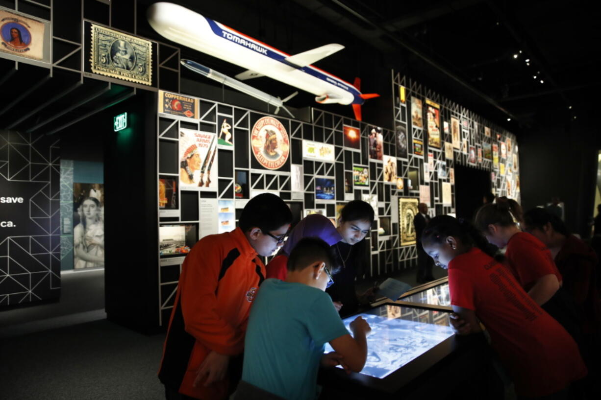 A school group explores an interactive touch table to learn about the objects and images on display at the “Americans” exhibit Feb. 9 at the Smithsonian’s National Museum of the American Indian in Washington. The exhibit uses Native imagery to show how it permeates American culture.