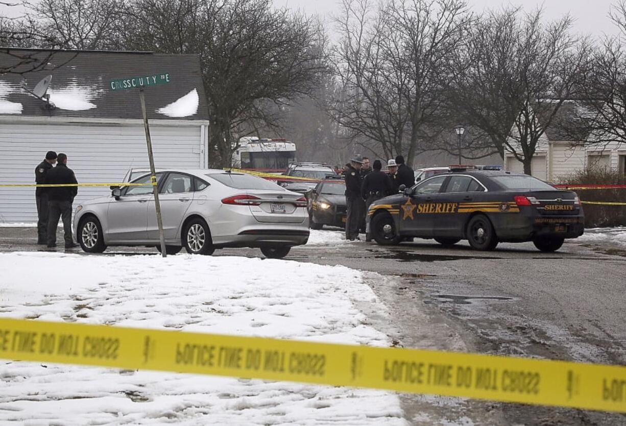 Authorities investigate the scene of a shooting where two Westerville, Ohio, police officers were shot and killed responding to a hang-up 911 call Saturday.