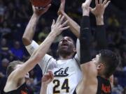 California’s Marcus Lee (24) shoots between Oregon State’s Zach Reichle, left, and Gligorije Rakocevic, right, in the first half of an NCAA college basketball game Saturday, Feb. 3, 2018, in Berkeley, Calif.