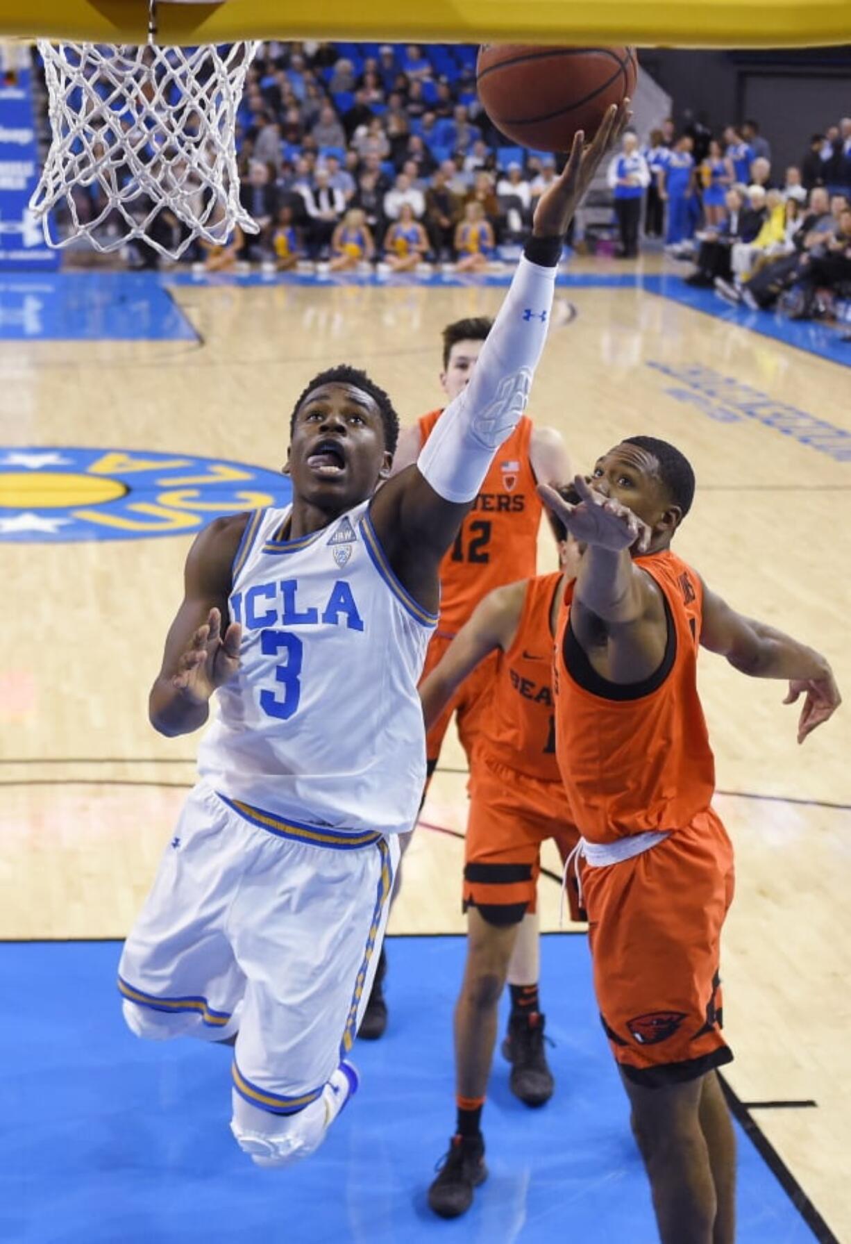 UCLA guard Aaron Holiday, left, shoots as Oregon State forward Alfred Hollins defends during the first half of an NCAA college basketball game Thursday, Feb. 15, 2018, in Los Angeles. (AP Photo/Mark J.