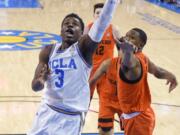 UCLA guard Aaron Holiday, left, shoots as Oregon State forward Alfred Hollins defends during the first half of an NCAA college basketball game Thursday, Feb. 15, 2018, in Los Angeles. (AP Photo/Mark J.