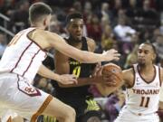 Oregon forward Troy Brown (0) drives against Southern California’s Nick Rakocevic, left, and Jordan McLaughlin (11) during the first half of an NCAA college basketball game, Thursday, Feb. 15, 2018, in Los Angeles.