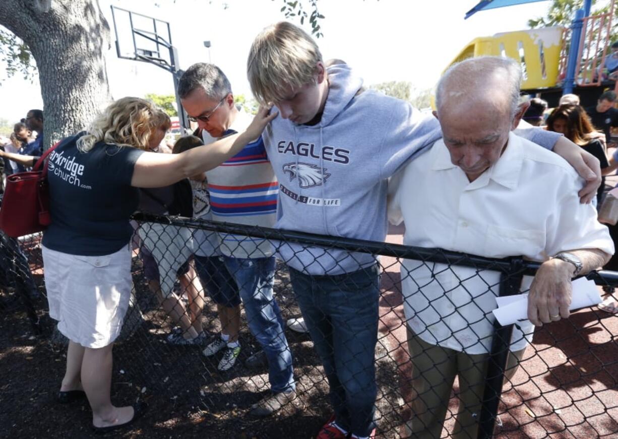 Attendees pray together at a vigil for the victims of the shooting at Marjory Stoneman Douglas High School at the Parkland Baptist Church, Thursday, Feb. 15, 2018 in Parkland, Fla. Nikolas Cruz, a former student, was charged with 17 counts of premeditated murder Thursday morning.