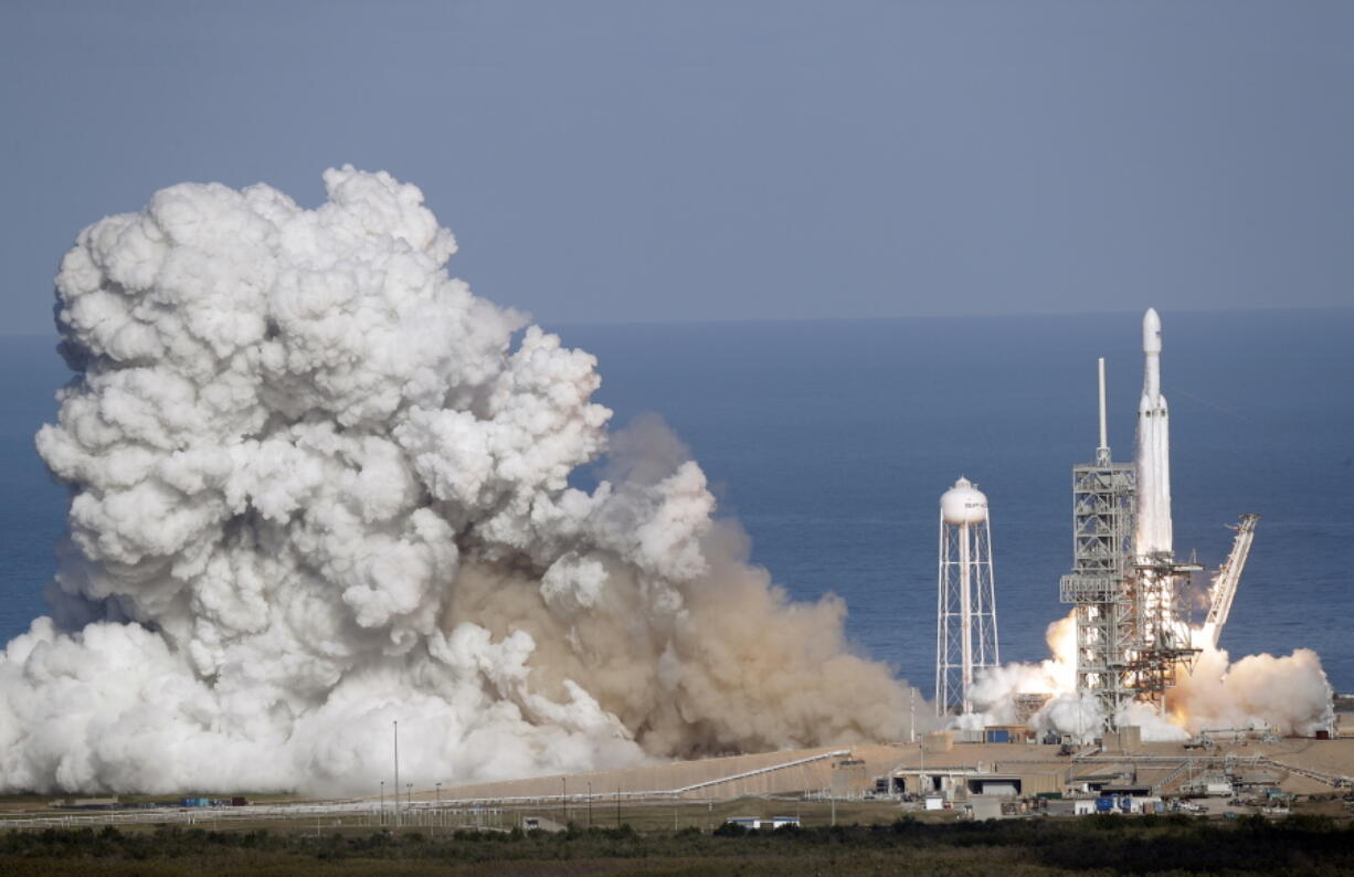 A Falcon 9 SpaceX heavy rocket lifts off from pad 39A on Tuesday at the Kennedy Space Center in Cape Canaveral, Fla. The Falcon Heavy has three first-stage boosters, strapped together with 27 engines in all.