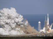 A Falcon 9 SpaceX heavy rocket lifts off from pad 39A on Tuesday at the Kennedy Space Center in Cape Canaveral, Fla. The Falcon Heavy has three first-stage boosters, strapped together with 27 engines in all.