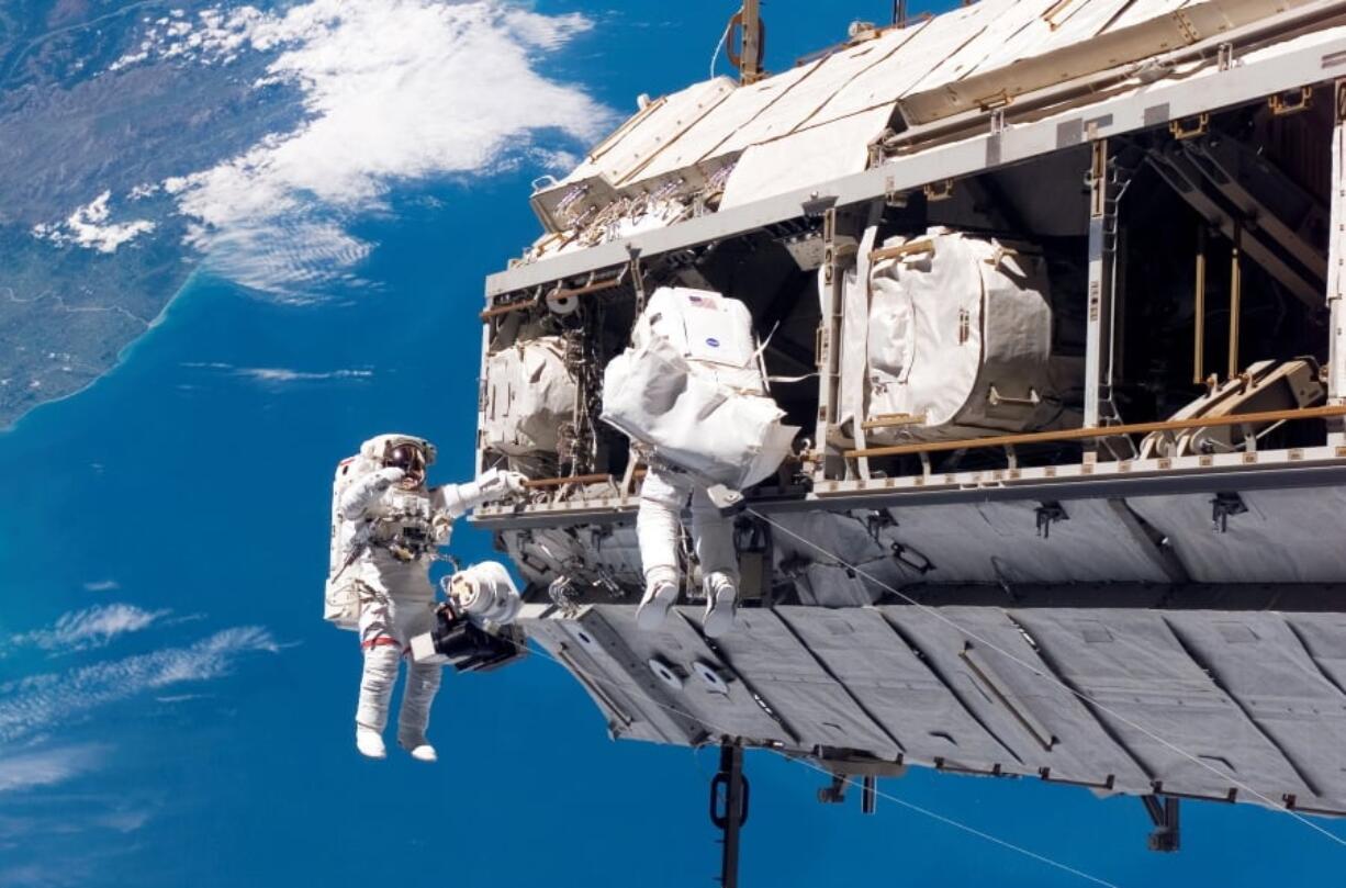 FILE - In this Dec. 12, 2006, file photo, made available by NASA, astronaut Robert L. Curbeam Jr., left, and European Space Agency astronaut Christer Fuglesang, participate in a space walk during construction of the International Space Station. Under President Donald Trump’s 2019 proposed budget released, Monday, Feb. 12, 2018, U.S. government funding for the space station would cease by 2025. The government would set aside $150 million to encourage commercial development.