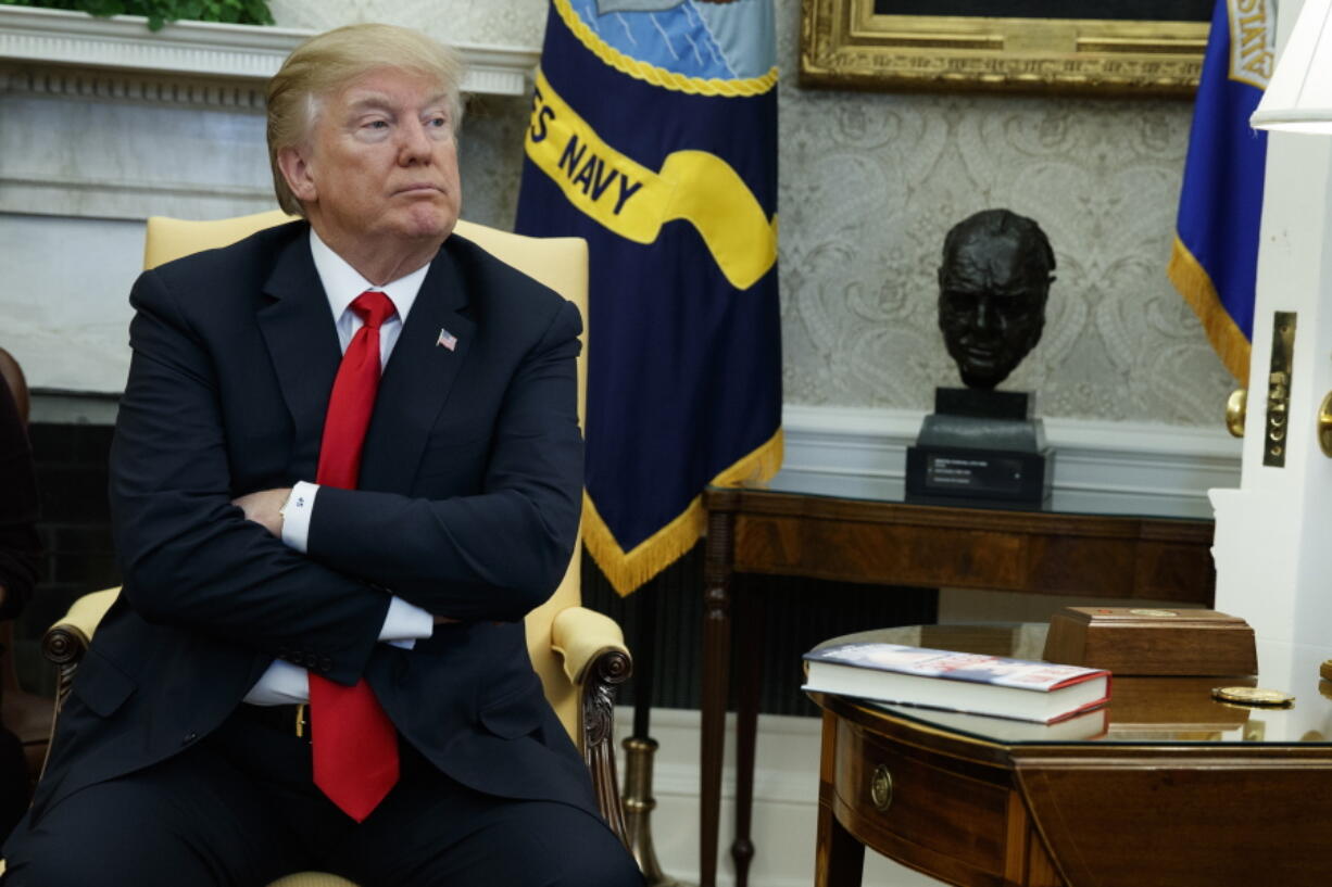 In this Friday, Feb. 2, 2018 file photo, President Donald Trump listens during a meeting with North Korean defectors where he talked with reporters about allowing the release of a secret memo on the FBI's role in the Russia inquiry, in the Oval Office of the White House in Washington. Congress has released a redacted, declassified memo that aims to counter GOP allegations that the FBI abused government surveillance powers in its investigation into Russian election interference. President Donald Trump had less concern about an earlier classified memo written by Republicans, which he declassified Feb. 2 over strong objections from the FBI.