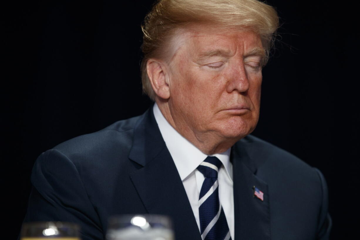 President Donald Trump prays during the National Prayer Breakfast on Thursday in Washington.