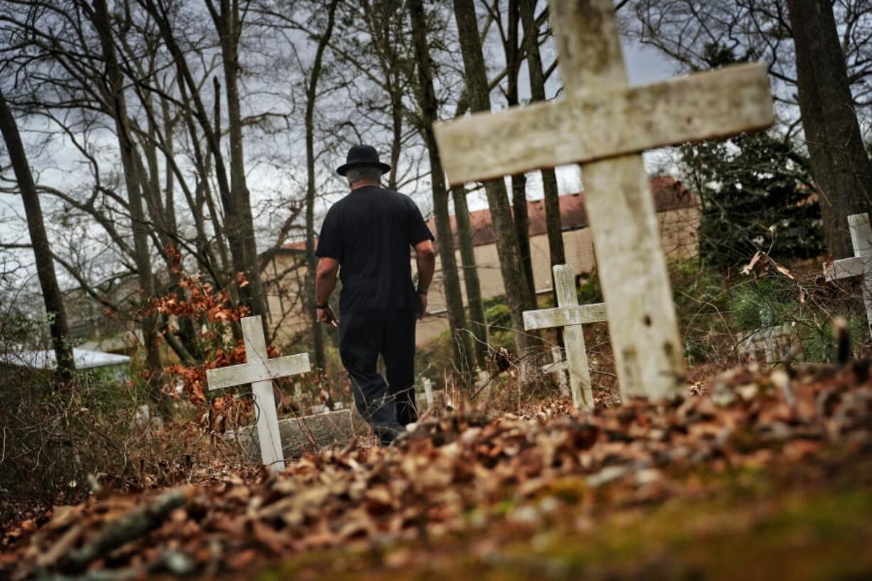 Tyrone Brooks, a veteran civil rights activist, walks through a historic African American cemetery where unknown graves are marked with white crosses and where one of the 1946 lynching victims is buried in Monroe, Ga., on Thursday. Law enforcement revisited the case in the 1990s after people came forward promising new information, though investigators said they still couldn’t prosecute anyone. In June 2000, then-Gov. Roy Barnes ordered the Georgia Bureau of Investigation to reopen the case. That investigation closed in January and the bureau made public its redacted case file, including interviews, leads followed, case summaries and press clippings.