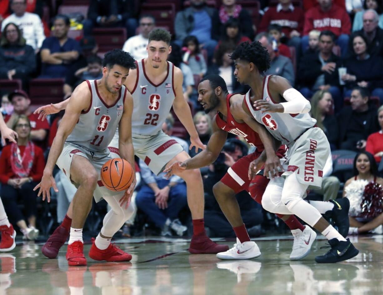 Stanford guard Dorian Pickens (11) steals the ball from Washington State guard Milan Acquaah (5) as Stanford guard Daejon Davis, right, defends during the first half of an NCAA college basketball game Saturday, Feb. 24, 2018, in Stanford, Calif.