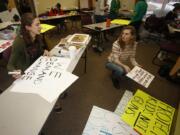 Vancouver School of Arts and Academics students Greta DuBois, left, and Aubree Radtke make signs at the Evergreen Education Association offices for the March for Our Lives, scheduled for Saturday. They’re among a group of student organizers leading the upcoming demonstration.