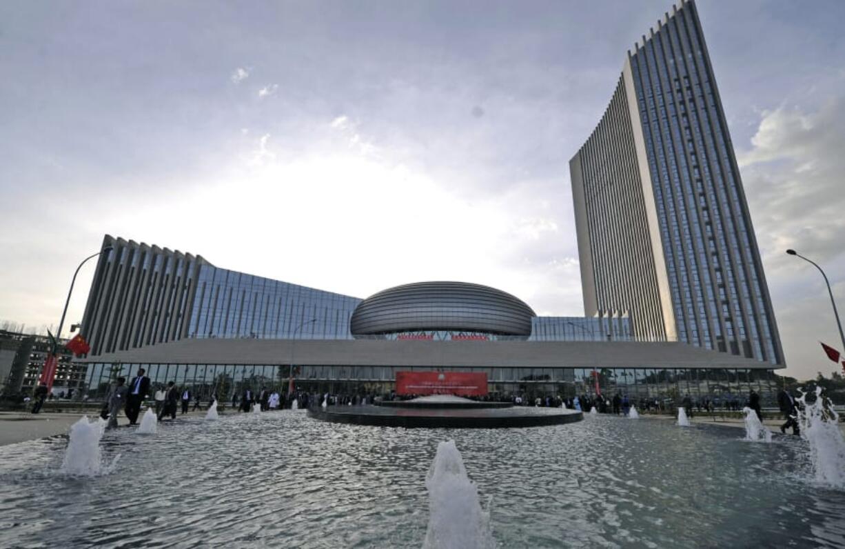 People gather before a red banner set up for the opening ceremony of the African Union Conference Center in Addis Ababa, Ethiopia, in 2012. The towering silver complex was built by China.