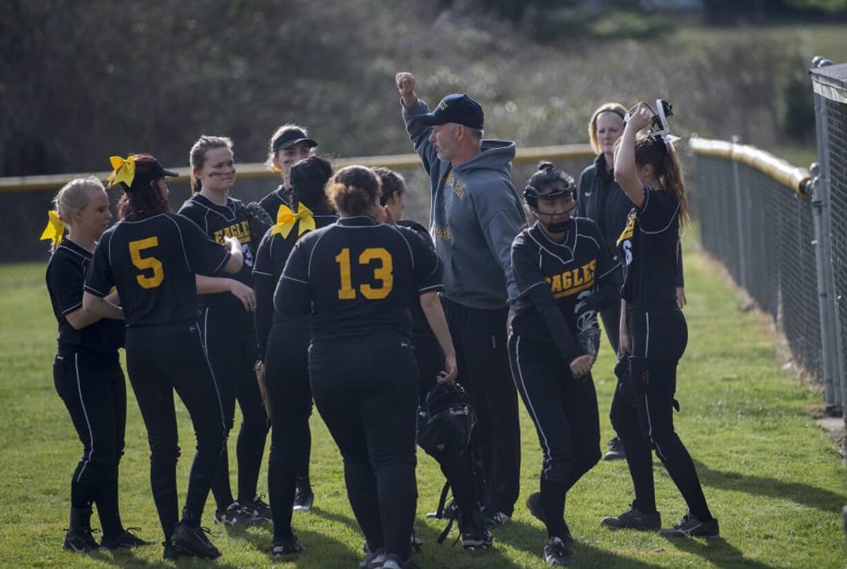 The Hudson’s Bay softball team gathers around coach Tony Christiansen in between innings in a game against Washougal on March 12. Hudson’s Bay is hoping success in fall slowpitch carries over to this spring.