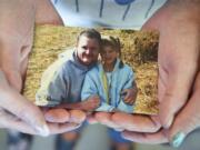 Mycheal Lynch's family holds a photo of their son, who died in the Clark County Jail in 2015. He is pictured with his niece in the photo, which was seen at Green & Ritchie PLLC in Vancouver in August.