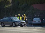 Officials look over the aftermath of a crash between a Subaru Legacy, foreground, and a Volkswagen Jetta near Columbia River High School on 99th Street on Tuesday morning, March 6, 2018. One person was confirmed dead in the crash.