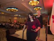 Community Hero award recipient Kim Mosiman, front, exits the stage after accepting her award from Kelly Schrader of IQ Credit Union during the American Red Cross 21st annual Hero Awards Breakfast at the Hilton Vancouver Washington on Friday morning.