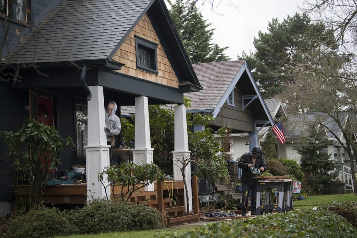 Dann Wynn, left, and J.P. Tugnon of Portland Painting & Restoration work on a home in the Hough neighborhood March 13. The Hough Neighborhood Association is in need of officers after both co-chairs resigned earlier this year.