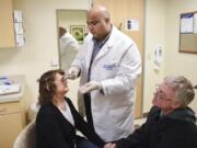 Neurologist Gurjeet Singh injects Botox into Kari Carlson’s forehead as her husband, Keith Carlson, offers his support. Carlson receives 31 Botox injections every 12 weeks to manage her chronic migraines.