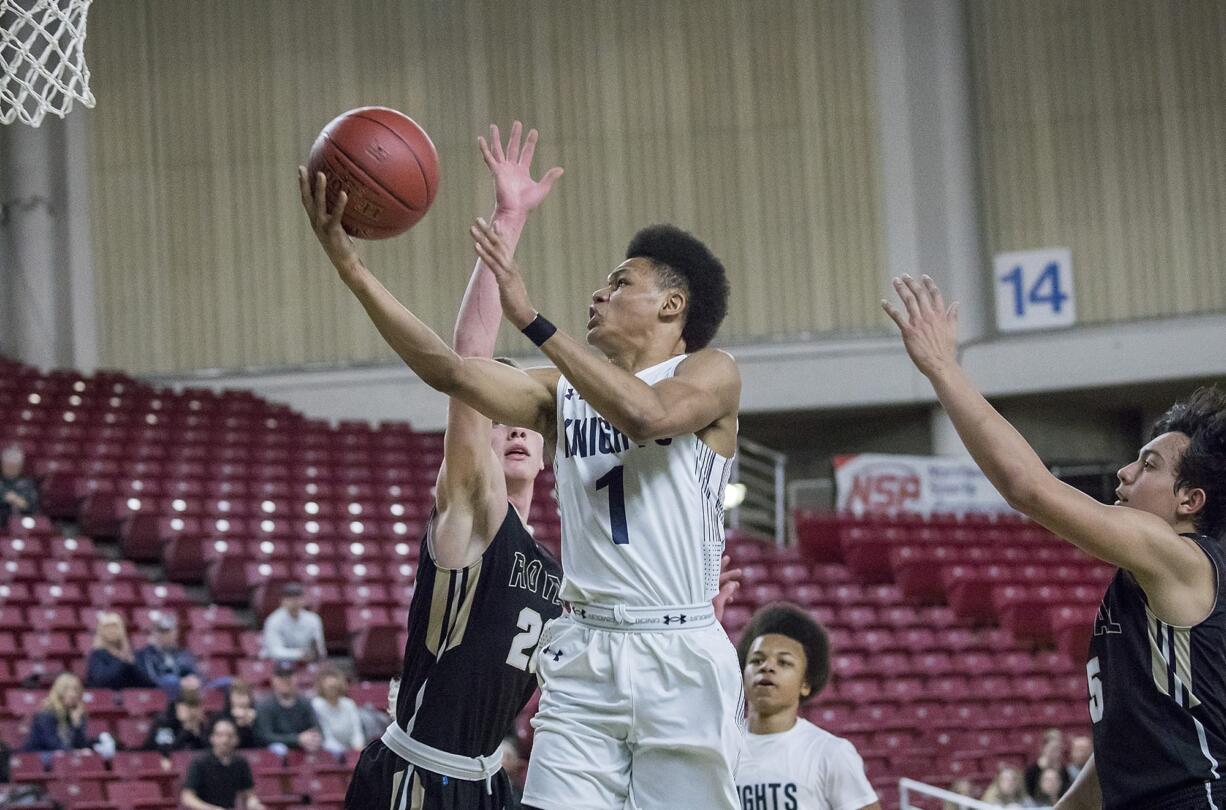 King's Way's Khalfani Cason (1) scores two points driving through the Royal Knights' defense of Angel Farias (5) and Corban Christensen (20) in the WIAA 1A boys state basketball tournament on Friday, Mar. 2, 2018, at the Yakima Valley SunDome. Royal Knights defeated King's Way Christian Knights 71-56.