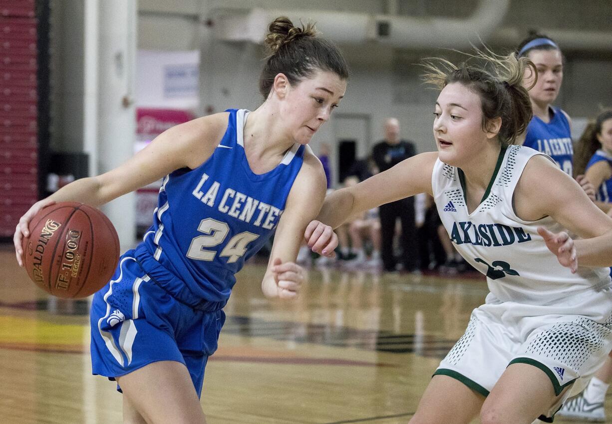 La Center's Taylor Stephens (24) drives through Lakeside's Maiya Martinez (22) committing a foul in the WIAA 1A girls state basketball tournament on Friday, March 2, 2018, at the Yakima Valley SunDome.