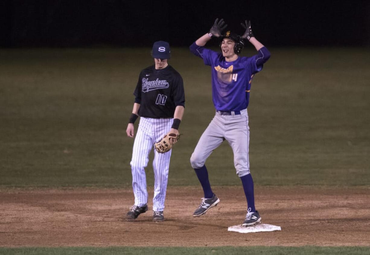 Columbia River’s Parker McNeil (14) signals back to his team after hitting a double during Friday night’s season-opening baseball game at Propstra Stadium against Skyview.