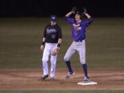 Columbia River’s Parker McNeil (14) signals back to his team after hitting a double during Friday night’s season-opening baseball game at Propstra Stadium against Skyview.