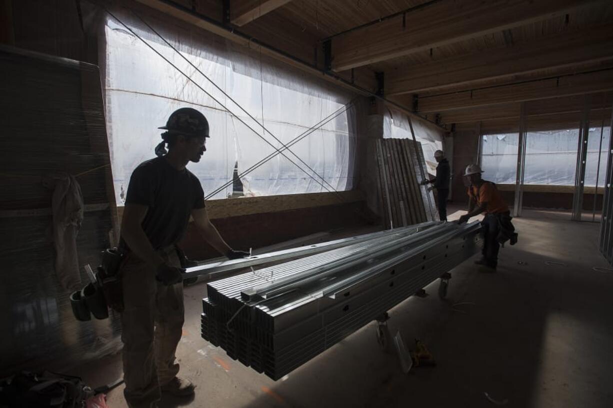 Brandon Neville of Harlens Drywall, foreground, works with colleagues at the upcoming Home Depot QuoteCenter headquarters on Columbia House Boulevard. Though it and other developments are sweeping through Clark County, builders say they are building more cautiously due to rising construction costs and an inevitable downturn on the horizon.