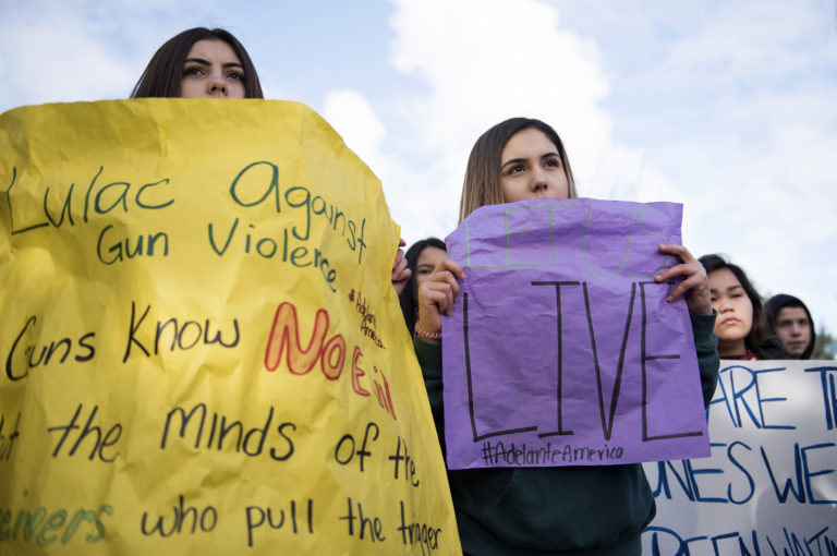 Fort Vancouver High School freshman Madilyn Bortolini, left, Sofia Mendez, center, and Teanna Francisco, right, gather for a school walkout to protest gun violence Wednesday morning, March 14, 2018 at Meadow Homes Park. The walkout was one of many held across the country honoring those killed in the Parkland, Fla. last month.