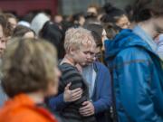 Camas High School sophomore Shannon McDaniel, 16, in stripes, and freshman Caleb Ashworth, 15, pause in a moment of silence outside their school Wednesday morning, March 14, 2018 to honor the memory of the 17 people killed in the Marjory Stoneman Douglas High School shooting in Parkland, Fla. The Camas school walkout was among the many that took place in high schools around the country.