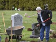 John Straub, commissioner and groundskeeper at Fern Prairie Cemetery in Camas, digs a hole for an urn of someone he once knew in the community.