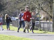 Third-graders Avery Ahrens, from left, Sam Coté and Karina Woodley run laps around the playground at Hough Elementary School. The trio are among the regular participants in the new Hough Mileage Club — a voluntary running program offered during lunch recesses.