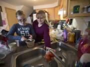 Jennifer Waller, right, prepares guacamole with daughter Kayla, 13, at their Battle Ground home. The family earns just below the median wage in Clark County but relies heavily on government programs such as food stamps and Women, Infants and Children to pay for groceries.