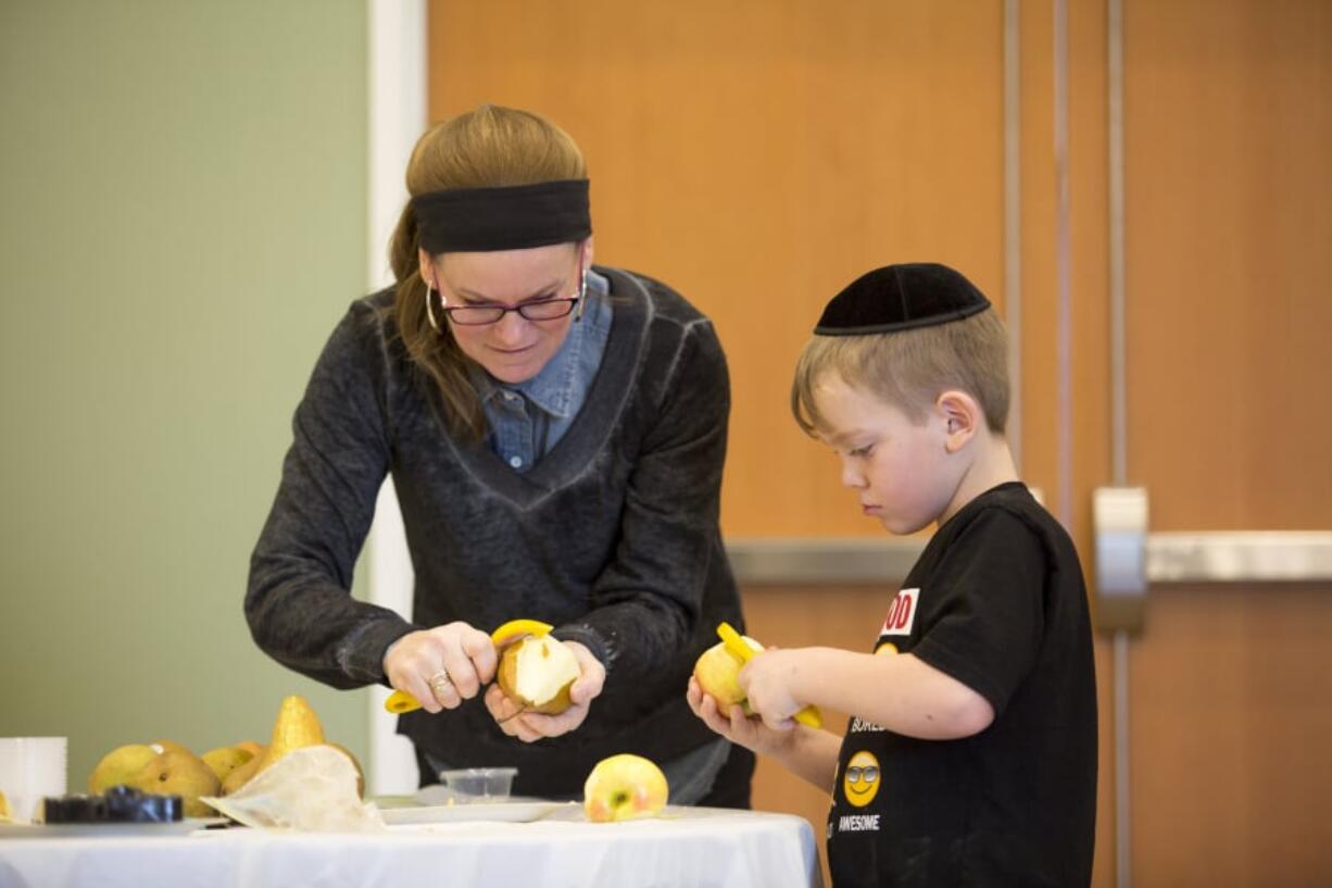 Sarah Mittelman and her son Ari, 7, prepare charoset, a fruit and nut paste, Sunday at the Chabad Jewish Center of Clark County.