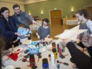 Families put together Seder plates shaped like the Star of David for the upcoming Passover holiday at the Chabad Jewish Center.