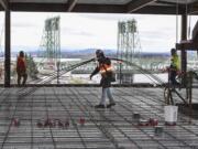 Fidel Camacho, center, of Farwest Steel, moves rebar on the sixth floor of the seven-story office tower at the Vancouver waterfront, Friday March 23, 2018. Crews were laying down rebar Friday to prepare for pouring concrete on the sixth floor this coming Monday.