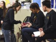 Evergreen High School student Samantha Robles, left, reviews lines and stage directions with Reymi Shelton and Jesus Coronel from their script. As far as anyone knows, Friday night’s performance will be the first Spanish-language play staged by the Evergreen School District.