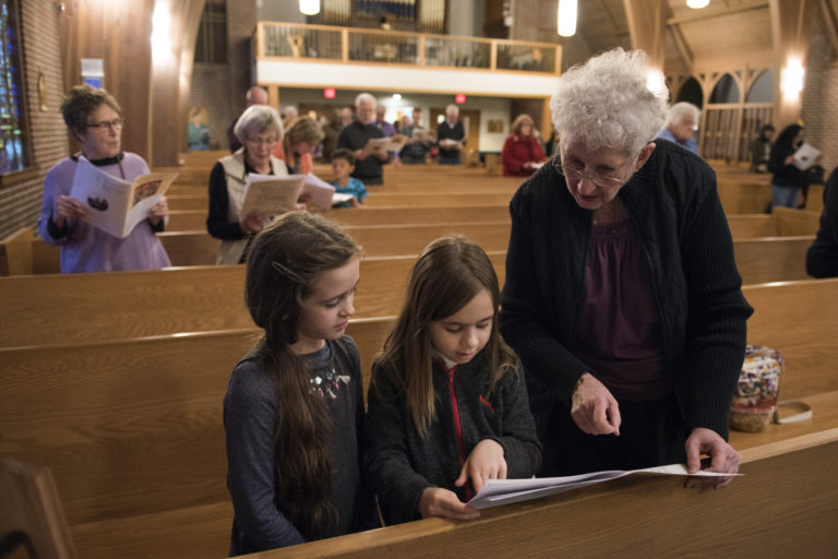 Michaela Friends of Portland, 8, left, Ella Cooper of Ridgefield, 8, center, and Friends' great-aunt Mary Maxon of Vancouver sing together during the bilingual Maundy Thursday service at St. Luke's Episcopal Church in Vancouver on March 29, 2018.