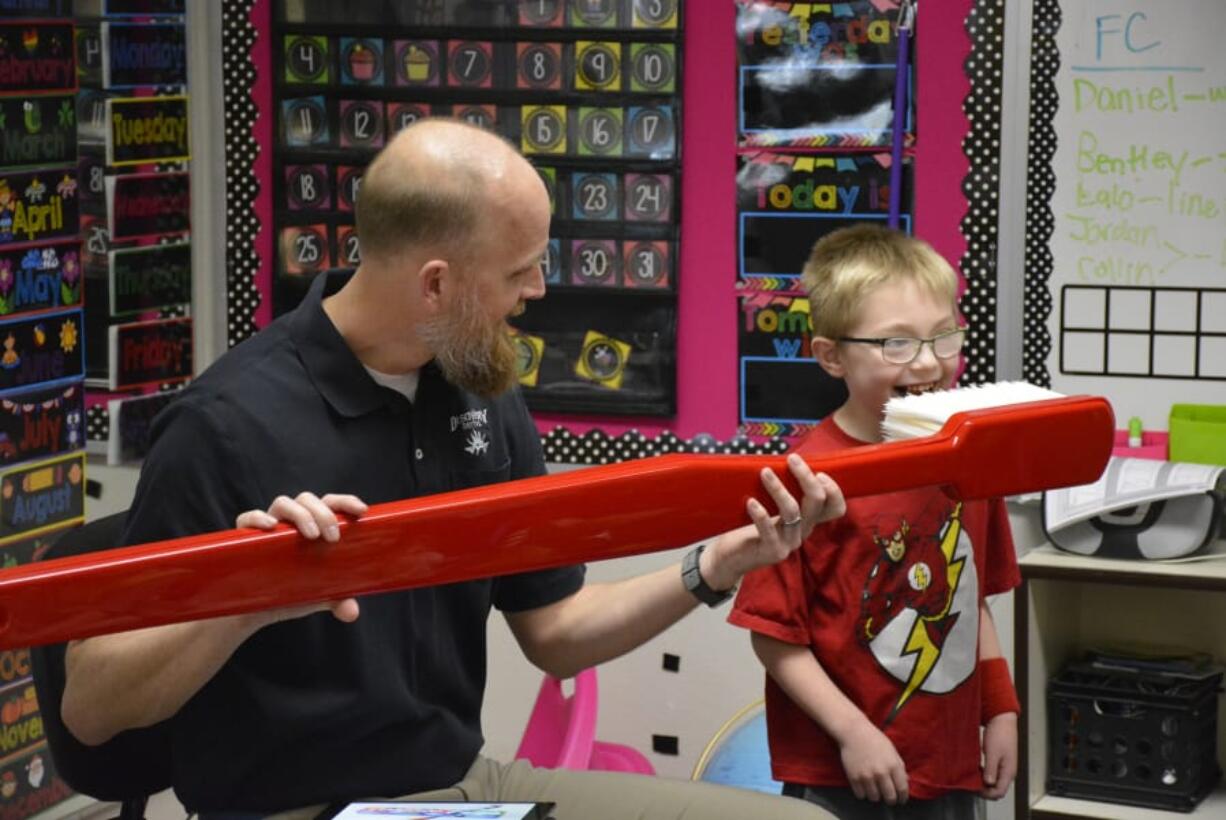 Washougal: Dave Stinchfield of Discovery Dental visited students at Hathaway Elementary School, including kindergarten student Gracin Hobensack, to talk about oral hygiene.