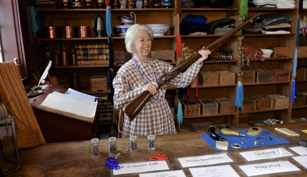 Fort Vancouver National Historical Site volunteer Rosanne Petersen holds up a musket in the trading post room on Saturday during a Women’s History Month event. Petersen showed visitors what items people could trade in or trade for at the fort, including muskets, blankets and girls of marriageable age.